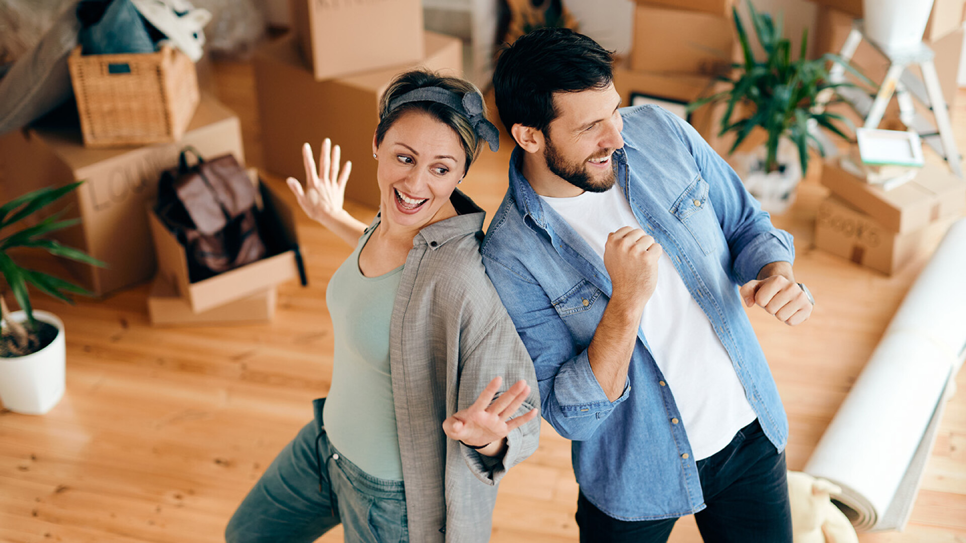 Carefree couple having fun- dancing after moving into new home